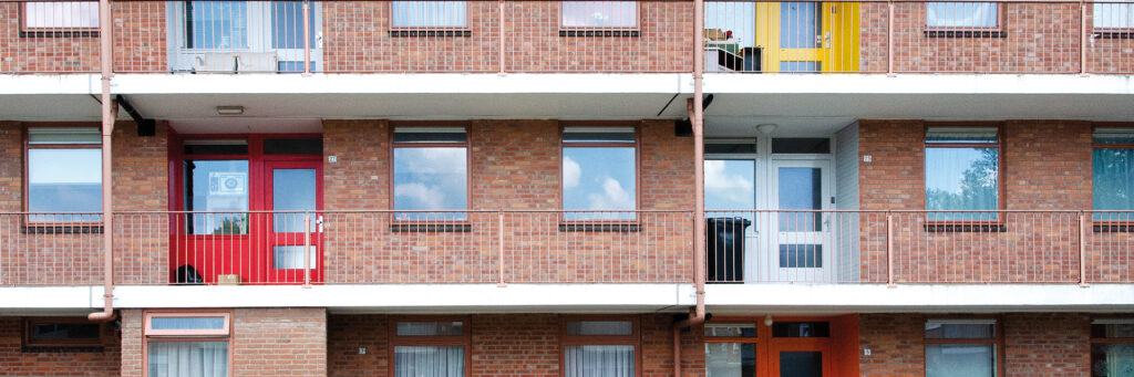 Appartementencomplex met bruine bakstenen muur en verschillende kleuren voordeuren