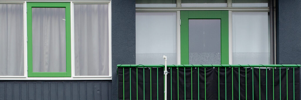 Appartement met groene raam, groene deur en groene balkon balustrades