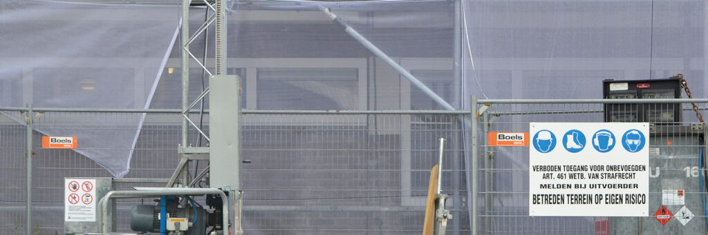 Woning die wordt verbouwd met stijgers voor de deur een een bord verboden toegang