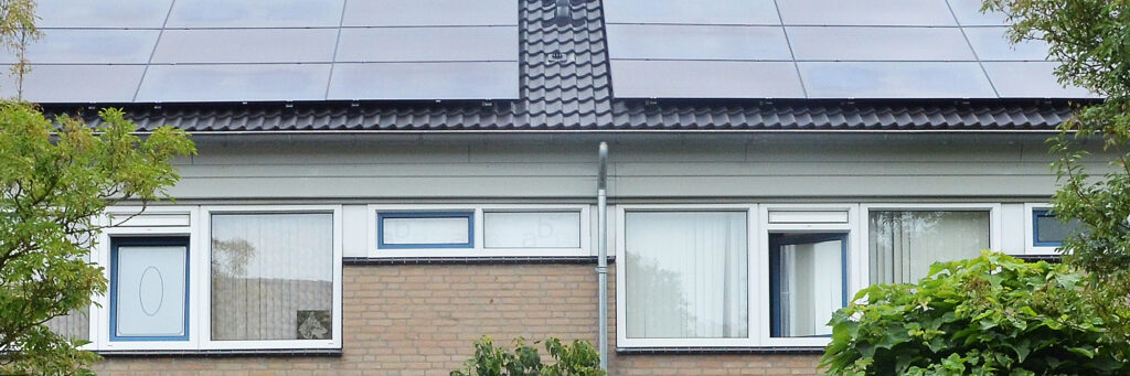 Eengezinswoning met witte kozijnen, crème bakstenen muur en zonnepanelen op het dak