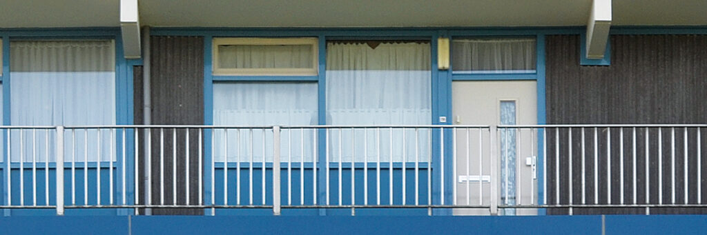 Appartementen complex met blauwe kozijnen, witte deur en blauwe balustrades