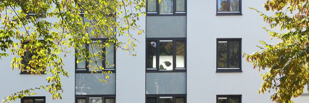 Appartementencomplex met een witte gevel en grijze kozijnen