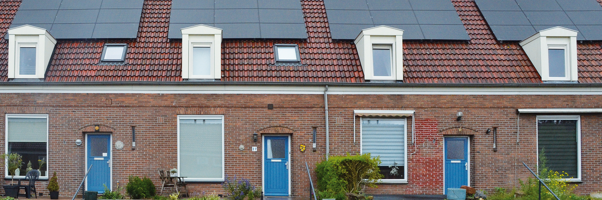 Eengezinswoningen met bruine bakstenen muur, witte kozijnen, blauwe deuren en zonnepanelen op het dak