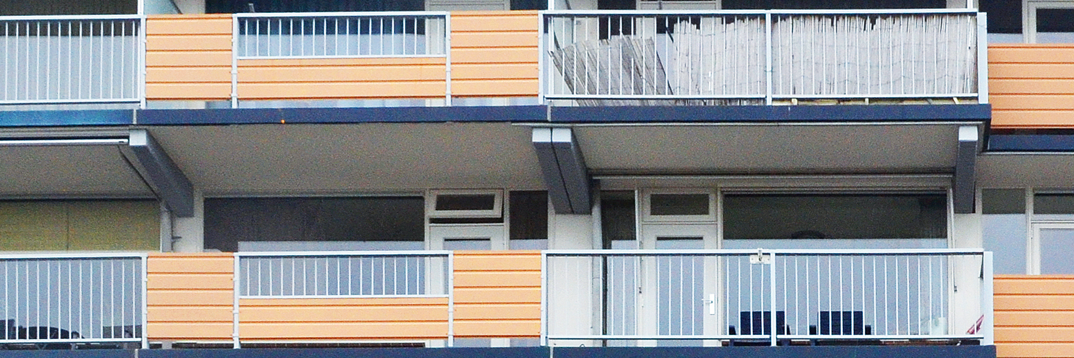 Appartementencomplex met witte kozijnen en gele balustrade