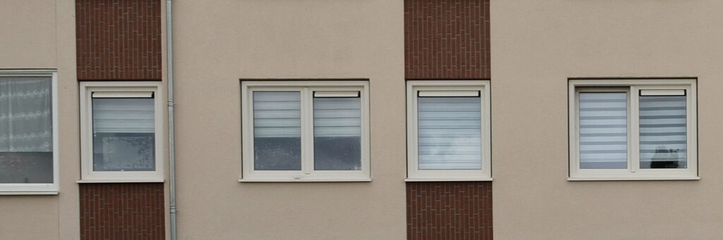 Appartementencomplex met crème gevel met een bruine streep en witte kozijnen