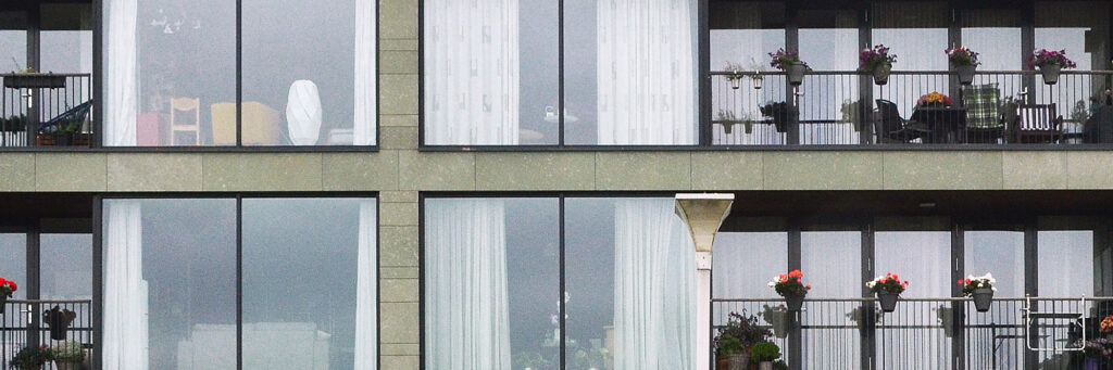Appartementen met veel ramen en balkon met planten