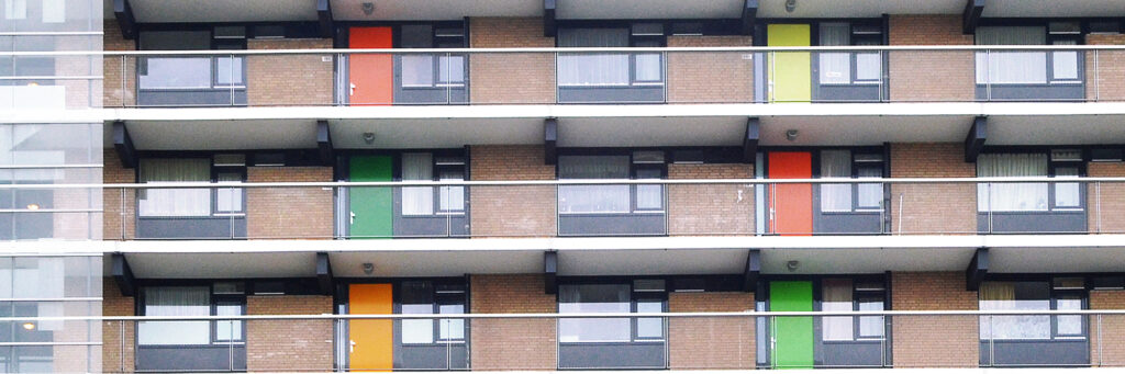 Appartementencomplex met bruine bakstenen muur en verschillende kleuren deuren