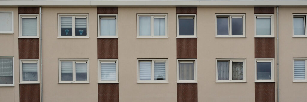 Appartementencomplex met crème gevel met een bruine streep en witte kozijnen
