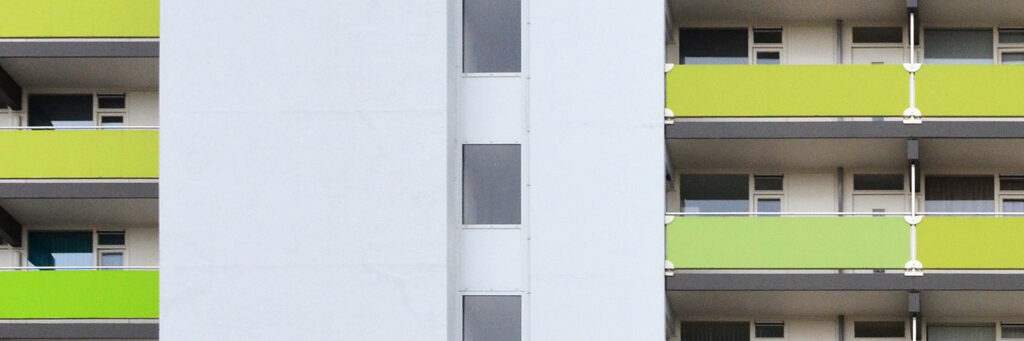 Appartementencomplex met witte gevel en groene balustrades