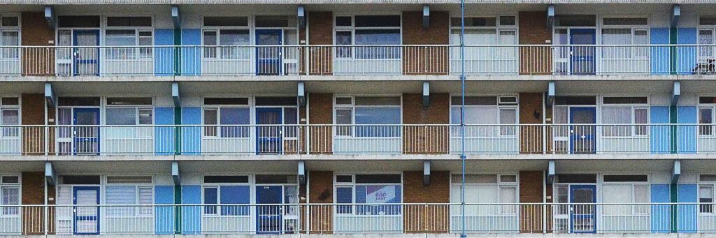 Appartementencomplex met bruine kanstenen geven, witte kozijnen, blauwe deuren en witte balustrade
