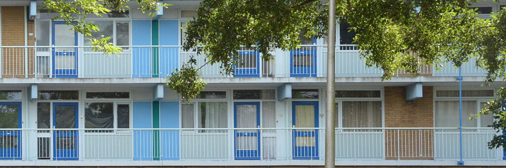 Appartementencomplex met witte kozijnen, blauwe deuren en witte balustrade