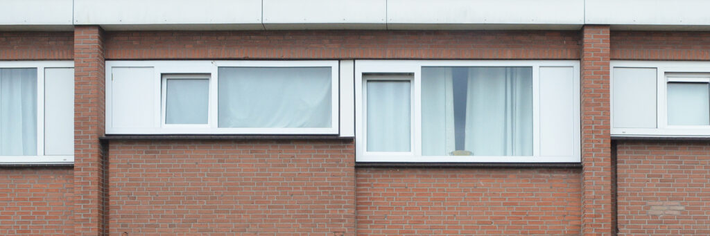 Woning bovenverdieping, bruine bakstenen muren en witte kozijnen