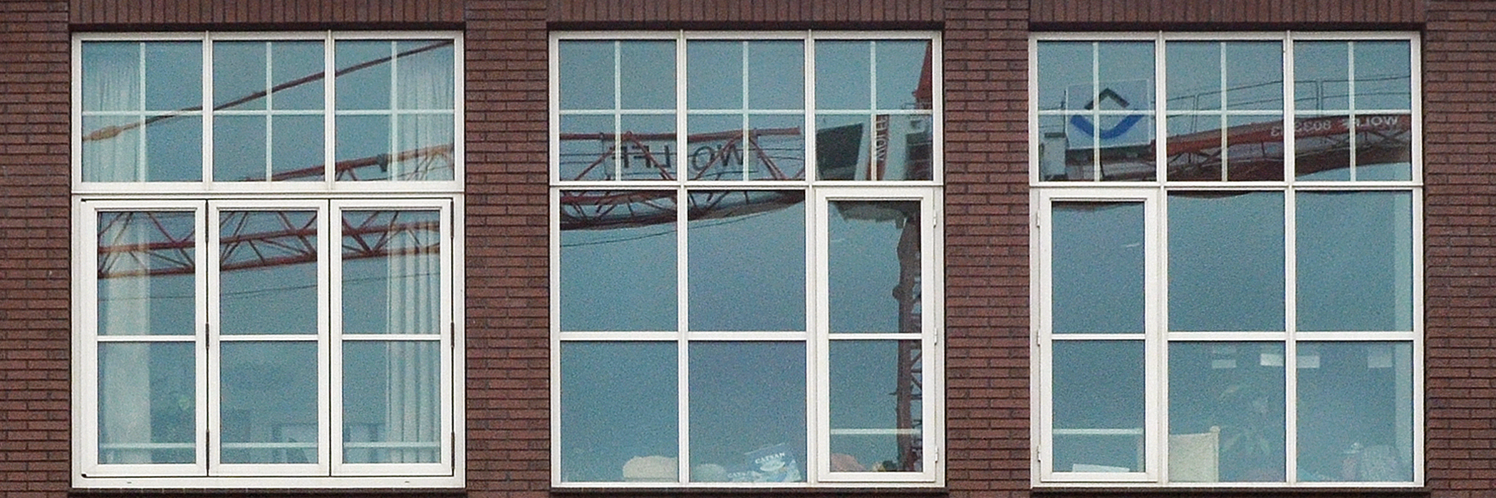 Appartementencomplex met donkerrode bakstenen gevel met witte kozijnen en veel ramen