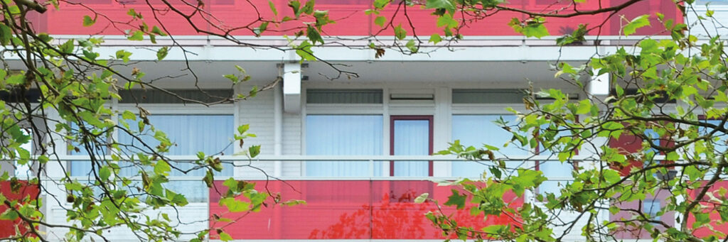 Appartementencomplex met witte kozijnen en rode balustrade