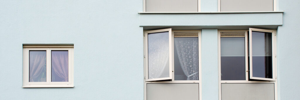 Appartement met lichtblauwe gevel, met witte en grijze kozijnen