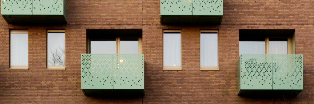Appartementencomplex met bruine bakstenen muur en groene balkons