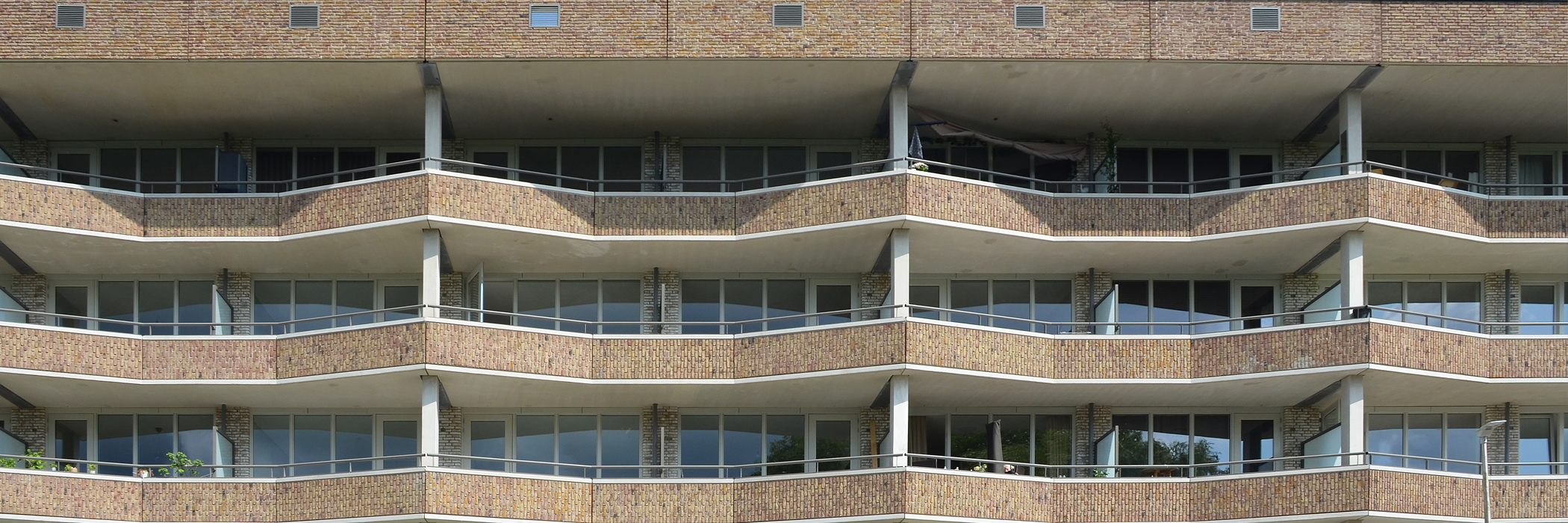 Appartementencomplex met bruine bakstenen gevel en driehoekige balkons