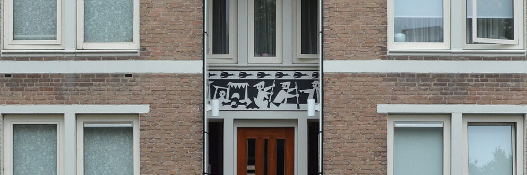 Woningen met bruine bakstenen gevel, witte kozijnen en bruine deur