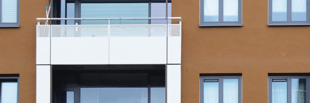 Appartementencomplex met bruine bakstenen gevel, grijze kozijnen en witte balkon balustrade