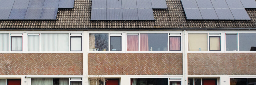 Woningen met bruine bakstenen gevel, witte kozijnen en zonnepanelen