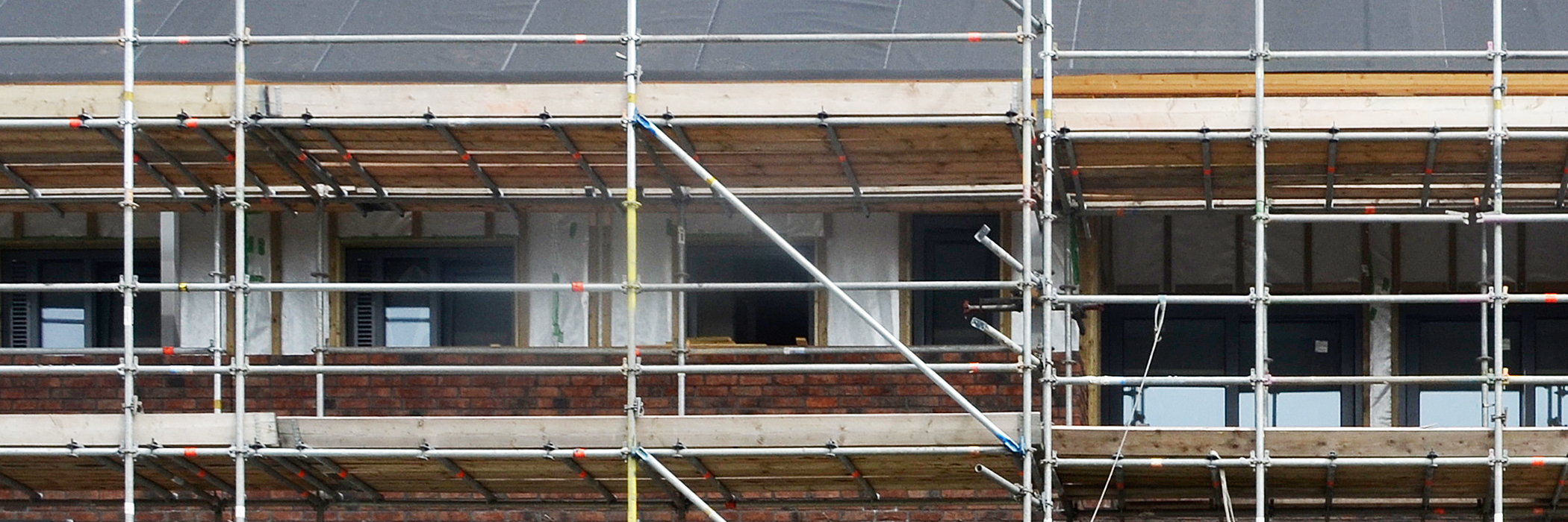 Appartementencomplex met bruine bakstenen gevel met stijgers ervoor