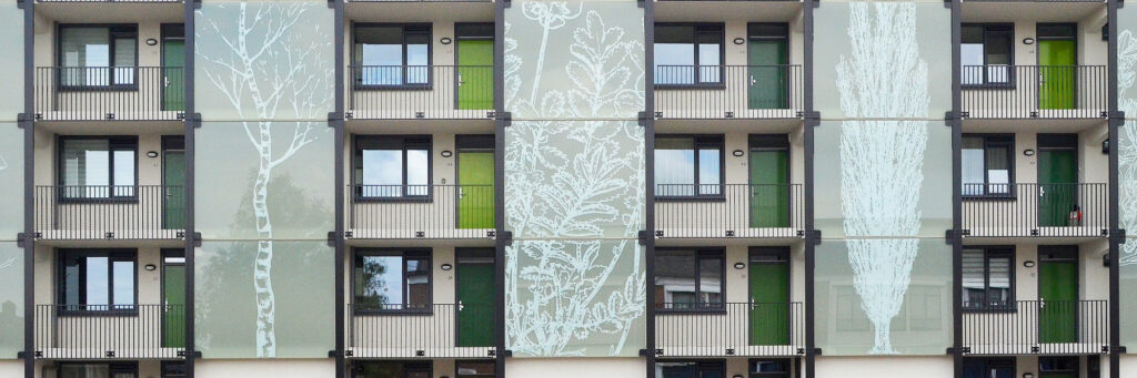 Appartementencomplex met witte gevel met groene platen en grijze balustrade