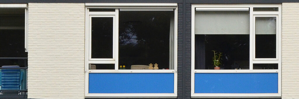 Appartementen met witte bakstenen gevel, witte kozijnen met blauwe platen