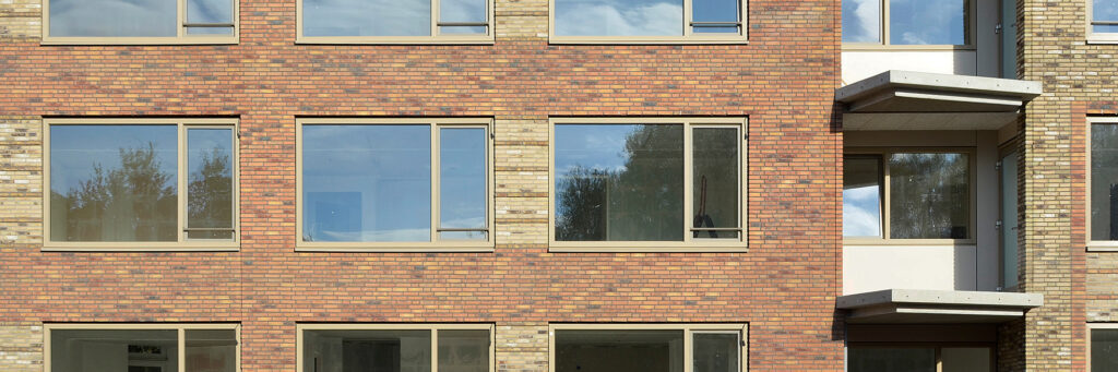 Appartementencomplex met lichtbruine bakstenen muur en crème gevels