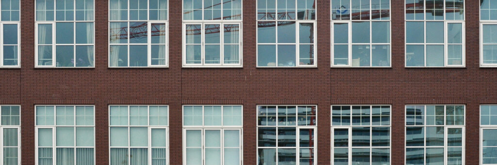 Appartementencomplex met donkerbruine bakstenen gevel en witte kozijnen