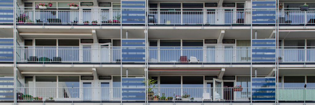 Appartementencomplex met witte kozijnen, blauwe balustrade