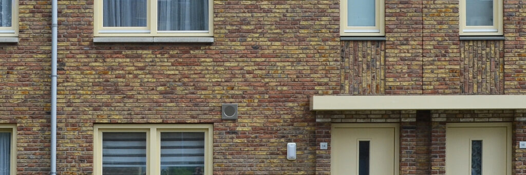 Woningen met lichtbruine bakstenen, crème kozijnen en deuren