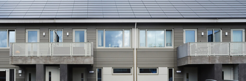 Woningen met grijze gevel, witte kozijnen en witte balustrade
