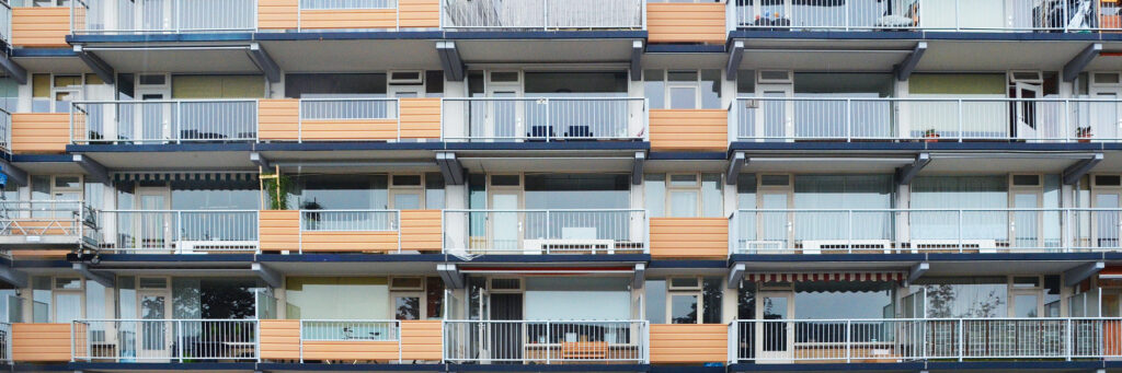 Appartementencomplex met witte kozijnen en oranje balustrade