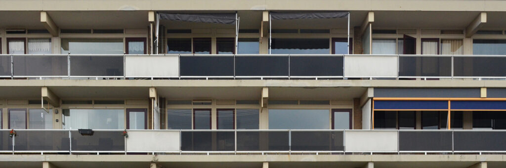 Appartementcomplex met crème kozijnen met witte en zwarte balustrade