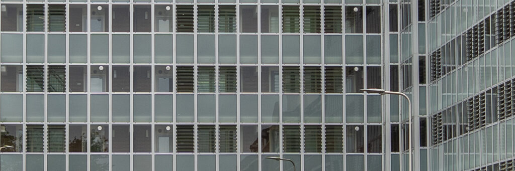 Appartementencomplex met veel ramen en een lantarenpaal voor de deur