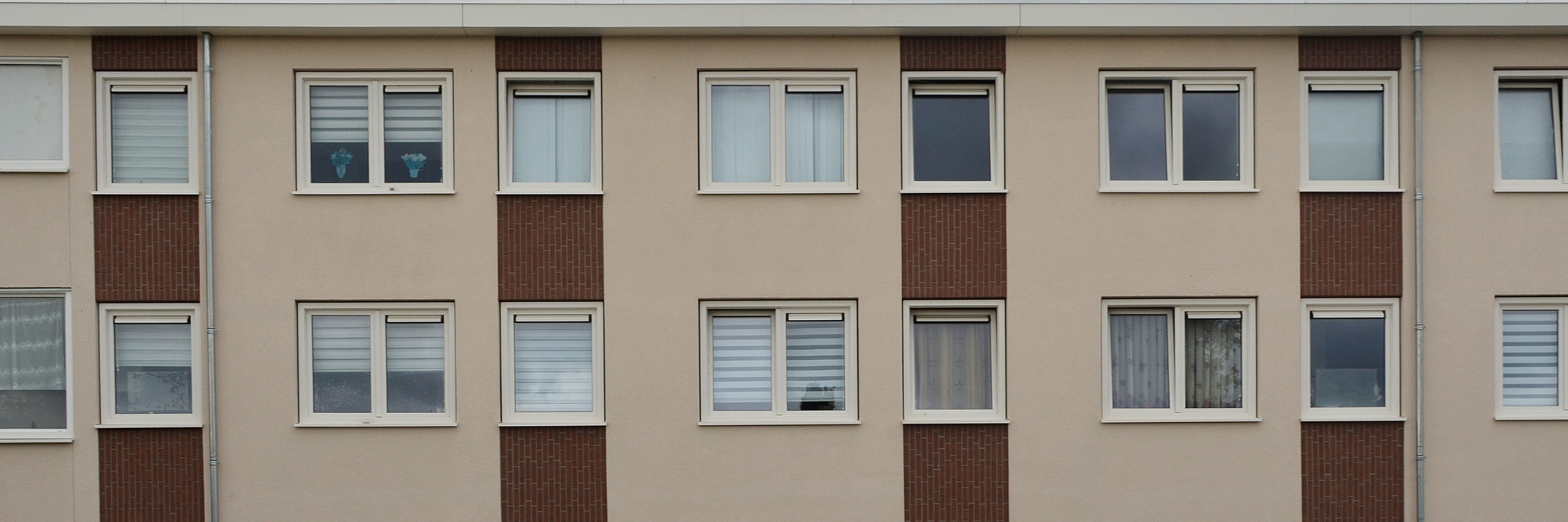 Appartementen met crème gevel met donkerbruine bakstenen en witte kozijnen