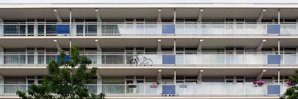 Appartementen met witte kozijnen, witte balustrade en blauwe vlakken voor de balustrades
