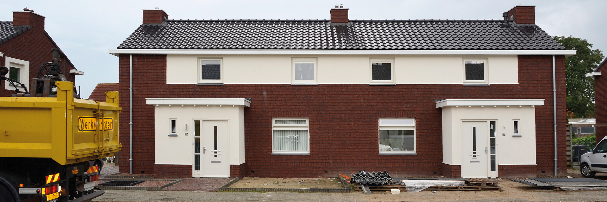 Twee-onder-een-kap woningen van bakstenen met een een witte uitbouw en een witte voordeur
