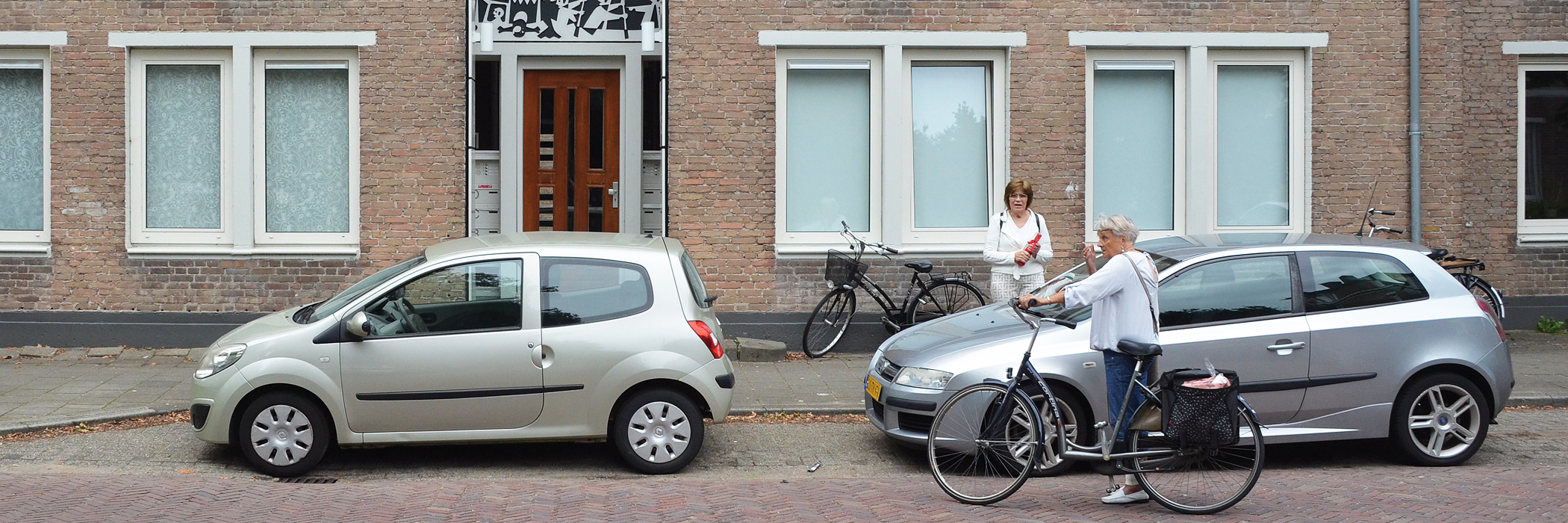 Woningen van bakstenen met witte kozijnen een houten voordeur