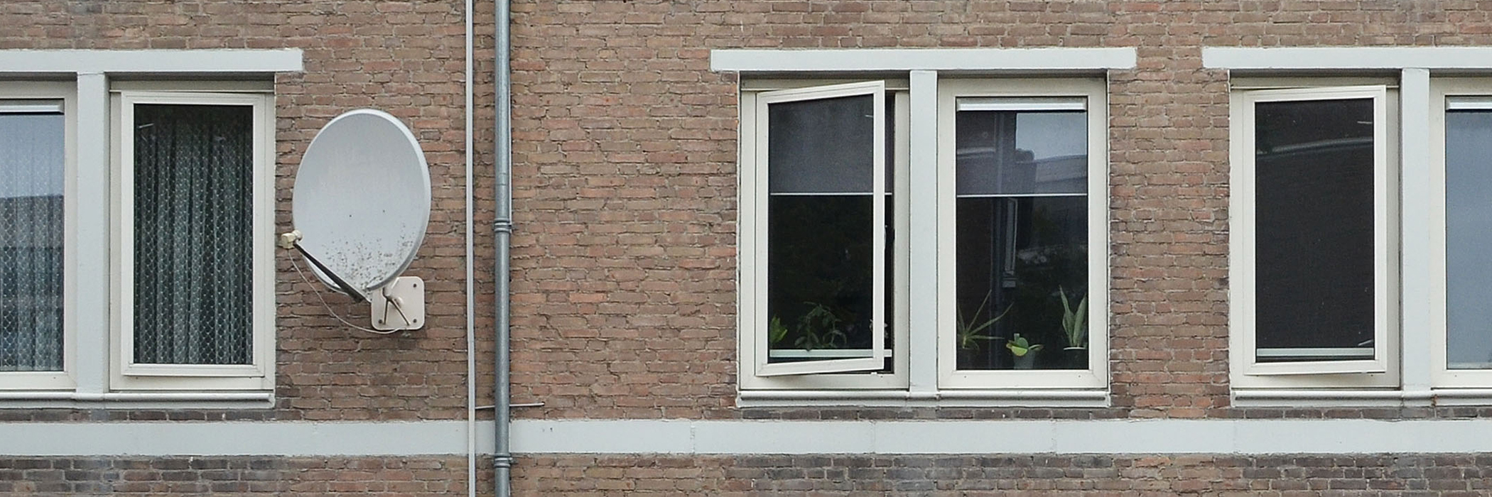 Woning met witte kozijnen rond de ramen met witte streep onder de ramen.