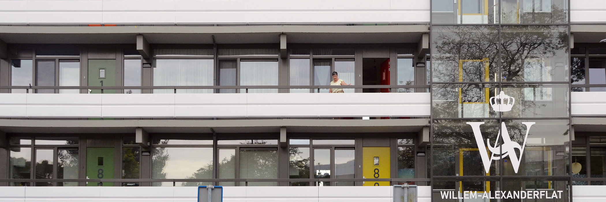 Appartementen met een balkon met een wit met grijs hekje, grijze kozijnen.