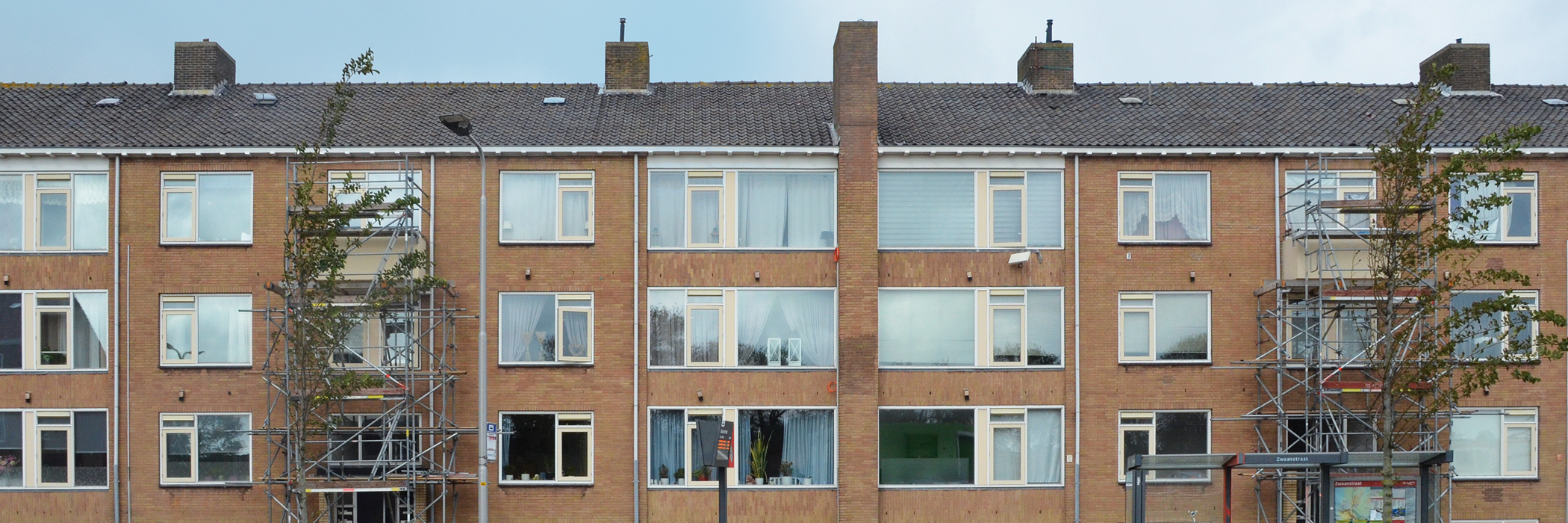 Woningen van bakstenen met gele kozijnen.