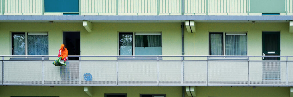 Appartementen met een mint groene gevel, witte kozijnen en zwarte voordeur.