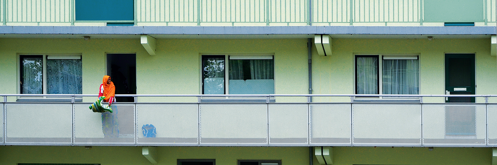Appartementen met een mint groene gevel, witte kozijnen en zwarte voordeur.