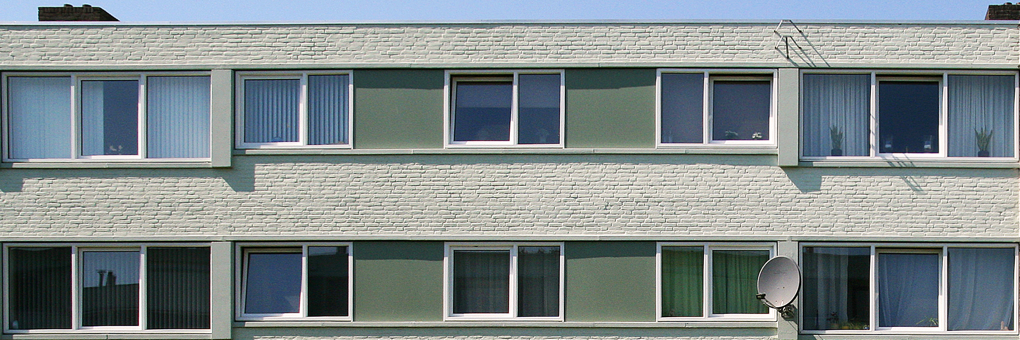 Woningen van witte bakstenen en witte kozijnen.