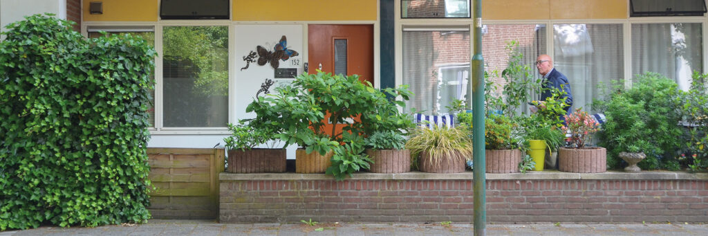 Benedenwoning met een kleine bruine schutting met planten.