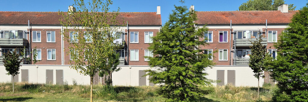 Woningen met onder een garage en een groenstrook met bomen