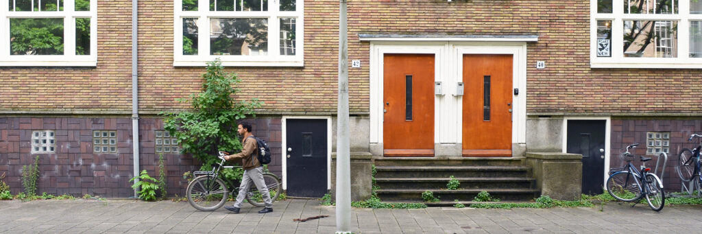 verhoogde entree van twee woningen met bruine deuren en witte deuren