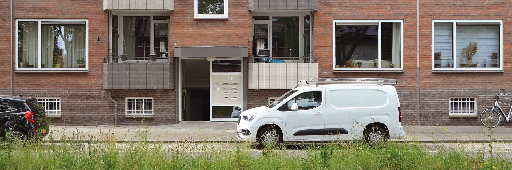 entree van een wooncomplex waar parkeergelegenheid voor de deur is