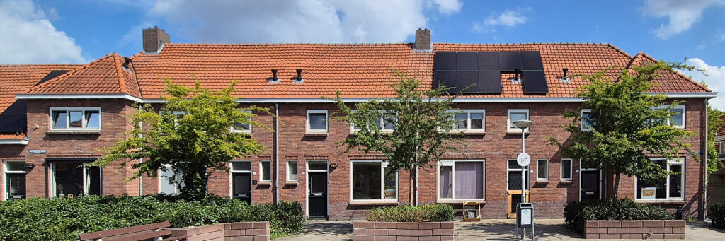 woningen met bomen ervoor. op het dak liggen zonnepanelen